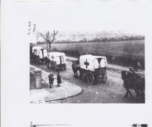 Two photographs showing horse-drawn ambulances with canvas covers marked with crosses on a road and a tented field in the distance.