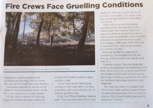 A newspaper clipping shows a firefighter in a yellow helmet spraying water onto a charred, wooded landscape at Holme Fen.