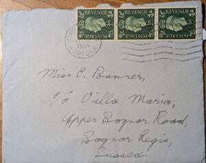 A grey envelope addressed in cursive script with three green half-penny stamps and a 1939 King's Lynn postmark.